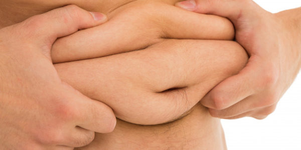 hombre sostiene su barriga.